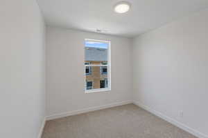 Carpeted empty room featuring baseboards