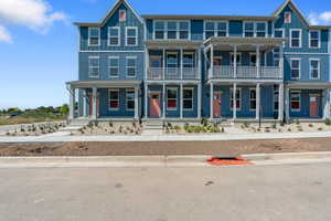 View of front of property featuring covered porch, a balcony, and board and batten siding