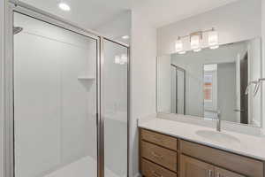 Bathroom featuring a shower stall and vanity
