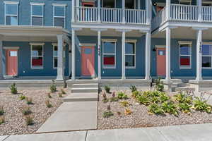 Doorway to property featuring covered porch, a balcony, and stucco siding