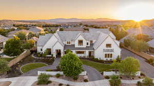 View of front of home with a standing seam roof, stucco siding, a metal roof, and a mountain view