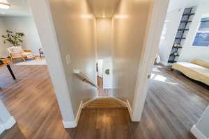 Staircase with wood finished floors and baseboards
