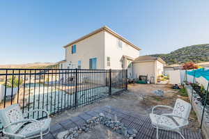 Back of property with a fenced backyard, a mountain view, stucco siding, and a swimming pool