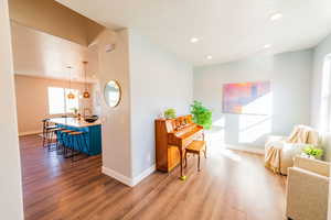 Living area with light wood-type flooring and recessed lighting
