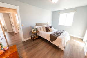 Bedroom with wood finished floors and baseboards