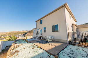 Back of house with a patio area, a fenced backyard, a mountain view, and stucco siding