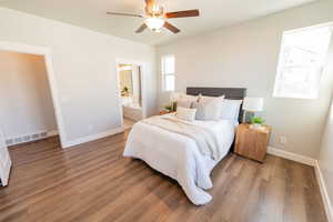 Bedroom featuring wood finished floors, ensuite bathroom, and a ceiling fan