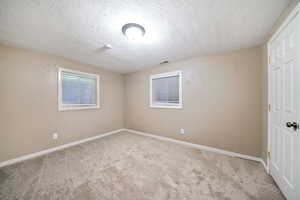 Unfurnished bedroom featuring carpet flooring and a textured ceiling