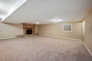 Unfurnished living room featuring carpet floors and a fireplace