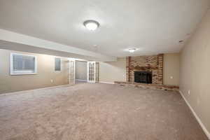 Unfurnished living room featuring electric panel, carpet, a fireplace, and a textured ceiling