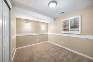 Unfurnished room featuring carpet floors and a textured ceiling