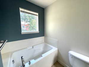 Full bathroom featuring a garden tub and tile patterned flooring