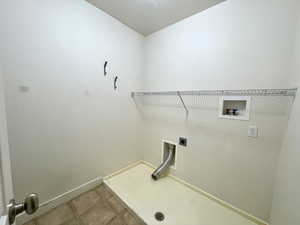 Laundry room featuring hookup for an electric dryer, hookup for a washing machine, and light tile patterned floors