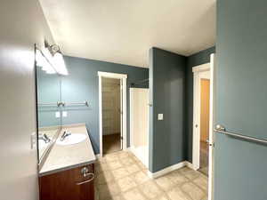 Full bath with vanity, a shower, and a textured ceiling