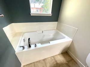 Bathroom with a bath and tile patterned floors