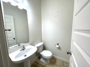 Half bath featuring toilet and tile patterned floors
