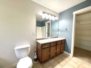 Full bath with vanity, a spacious closet, tile patterned flooring, and a shower