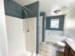 Full bathroom with vanity, a walk in shower, and a garden tub