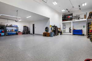 Garage featuring strapped water heater and a garage door opener