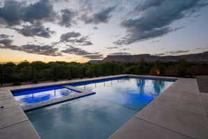 View of pool featuring a fenced backyard, a mountain view, and a pool with connected hot tub