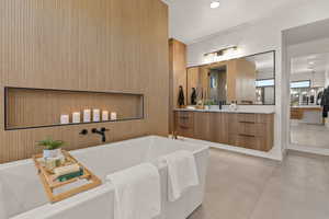 Full bathroom featuring a freestanding tub, vanity, light tile patterned floors, and recessed lighting
