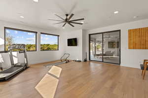 Workout room featuring light wood-style flooring, recessed lighting, and a ceiling fan