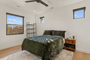 Bedroom with multiple windows, light wood finished floors, a ceiling fan, and recessed lighting