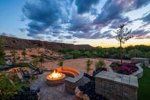 Patio terrace at dusk featuring an outdoor fire pit and a patio area