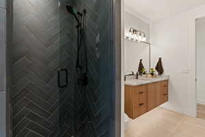 Full bathroom with vanity, a shower stall, and light tile patterned floors