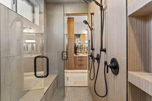 Bathroom with a shower stall, vanity, and tile patterned flooring