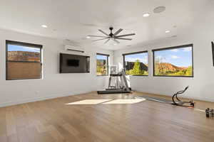 Workout area with light wood-style floors, ceiling fan, recessed lighting, and a wall mounted AC