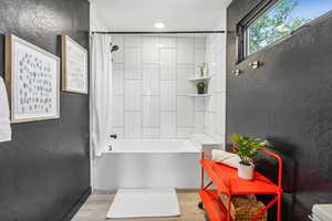 Full bathroom featuring shower / tub combo with curtain and wood finished floors