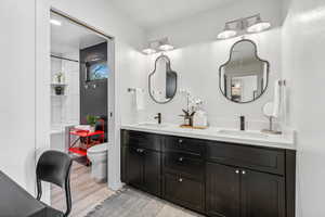 Full bath with double vanity and wood finished floors