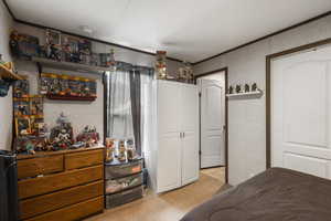 Bedroom featuring light carpet and ornamental molding