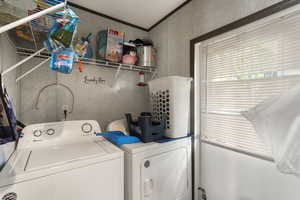 Laundry area featuring independent washer and dryer and ornamental molding