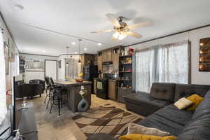 Living area featuring a ceiling fan, recessed lighting, and crown molding