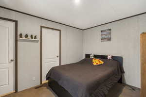 Carpeted bedroom featuring crown molding