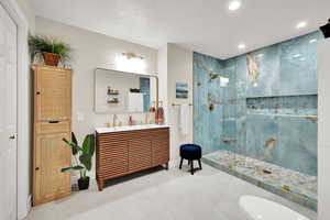 Full bathroom with a marble finish shower, double vanity, recessed lighting, and tile patterned flooring