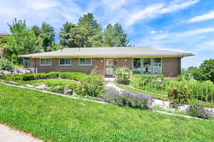 Ranch-style house with brick siding and a front yard