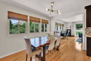 Dining room featuring light wood-type flooring, a chandelier, and an office area