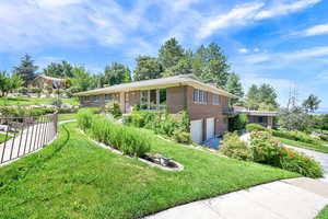 View of front of house featuring brick siding, an attached garage, and driveway