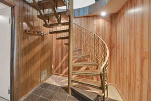 Staircase featuring wood walls