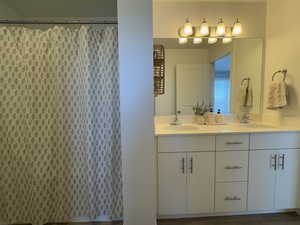 Bathroom featuring double vanity and a shower with shower curtain