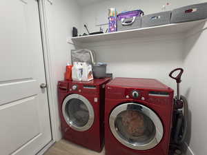 Laundry area featuring washer and dryer and wood finished floors