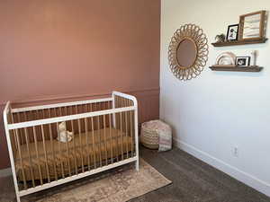 Carpeted bedroom with a wainscoted wall and a nursery area