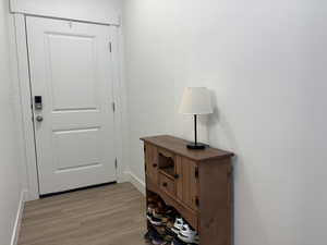 Doorway to outside featuring light wood-style flooring and baseboards