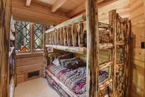 Bedroom featuring carpet floors and a wooden ceiling with exposed beams