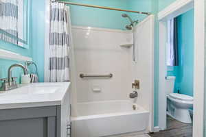 Full Bathroom with shower / tub combo and shower curtain, updated vanity, and LVP flooring