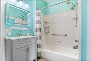 Full Bathroom with shower / tub combo and shower curtain, updated vanity, and LVP flooring