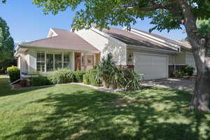 Ranch-style house with an attached garage, a front yard, roof with shingles, concrete driveway, and brick siding